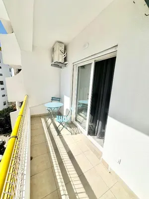 a balcony of a building with a table and chairs at Julio Apartment in Albufeira