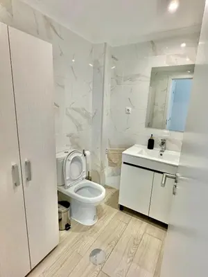 a white bathroom with a toilet and a sink at Julio Apartment in Albufeira
