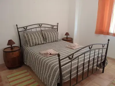 a bedroom with a bed with a black frame and two lamps at Albufeira INN - Mulatinho V3 in Olhos de Água