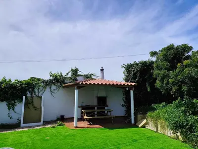 a small house with a picnic table in a yard at Albufeira INN - Mulatinho V3 in Olhos de Água