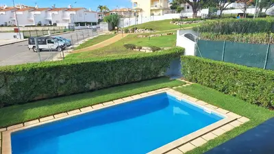 an overhead view of a blue swimming pool with grass at Apartamento Olhos do Mar in Olhos de Água