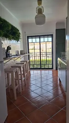 a kitchen with a tile floor with a table and chairs at Apartamento Olhos do Mar in Olhos de Água