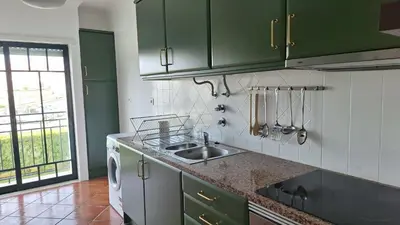 a kitchen with green cabinets and a sink at Apartamento Olhos do Mar in Olhos de Água