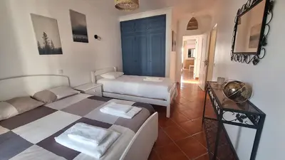 a room with two beds and a couch in it at Apartamento Olhos do Mar in Olhos de Água