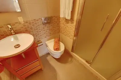 a bathroom with a toilet and a sink and a shower at Parque Atlântico Modern Seaview Apartment with Pool and Tennis Court in Cavacos