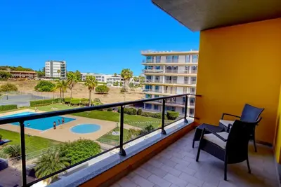 a balcony with a view of a building at Parque Atlântico Modern Seaview Apartment with Pool and Tennis Court in Cavacos