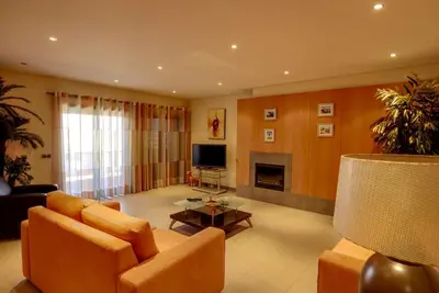 a living room with a couch and a television at Parque Atlântico Modern Seaview Apartment with Pool and Tennis Court in Cavacos
