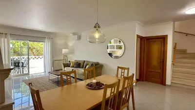 a dining room and living room with a table and chairs at Pine Cliffs by Check-in Portugal in Albufeira