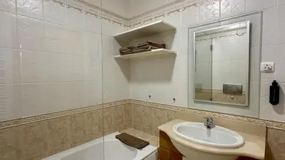 a bathroom with a sink and a mirror and a tub at Pine Cliffs by Check-in Portugal in Albufeira