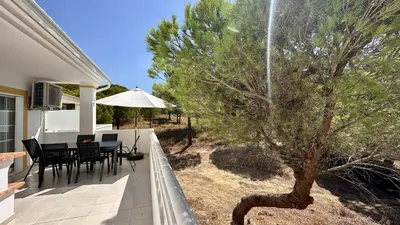 a patio with a table and chairs and a tree at Pine Cliffs by Check-in Portugal in Albufeira