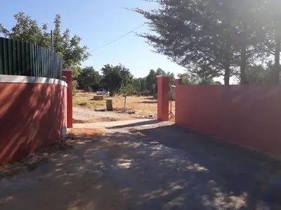an orange fence with a gate in a field at Casa Monte das Medronheiras in Vale Covo