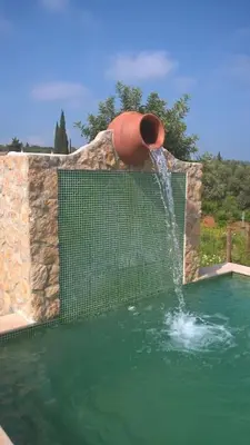 a water fountain in a swimming pool at Casa Monte das Medronheiras in Vale Covo