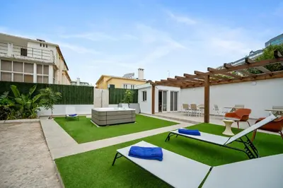an outdoor patio with green grass and a backyard with a pergola at Urban Bliss Guesthouse I in Faro