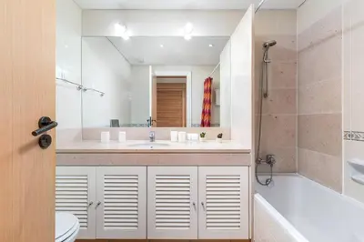 a bathroom with a sink and a tub and a toilet at Stylish 2BR Ground Floor Apartment in Vila Sol, Direct Garden and Poolside Acces in Quarteira