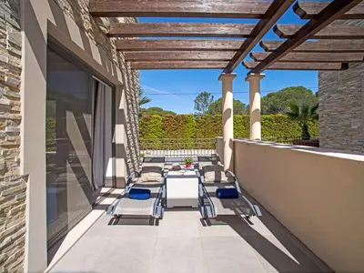 a patio with chairs and tables on a building at Apartment Pine Hills Diamante-12 by Interhome in Vilamoura