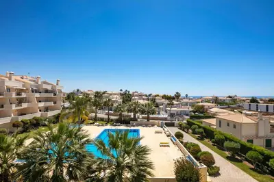 an aerial view of a resort with a swimming pool and palm trees at Lovely 2-Bed Apartment in Sao Rafael in Albufeira