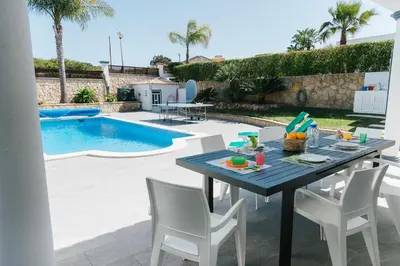 a kitchen with a table and chairs in a kitchen at Villa Jorge by Ecovillas Albufeira in Galé