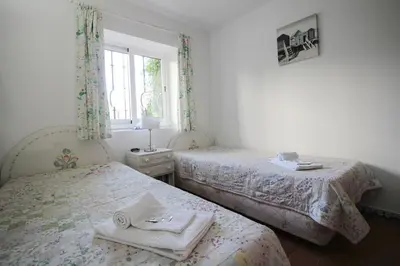 a bedroom with two beds and a window at Old Village- 2A Village Street in Quarteira