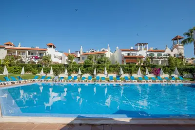 a large swimming pool with chairs and umbrellas at Old Village- 1A Village Gate in Quarteira