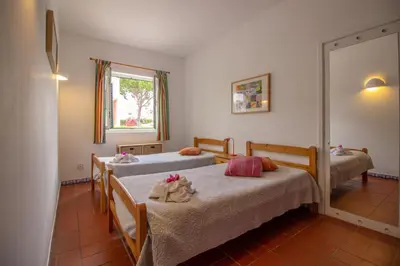 a bedroom with two beds and a mirror at Old Village- 1A Village Gate in Quarteira