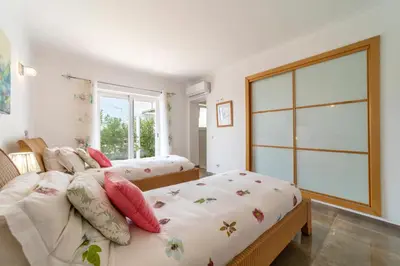 a bedroom with two beds and a large window at Stunning 4-Bedroom Villa With Pool - Perfect For Families in Albufeira