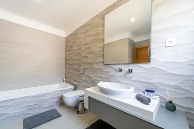 a bathroom with a sink and a toilet and a tub at Stunning 4-Bedroom Villa With Pool - Perfect For Families in Albufeira