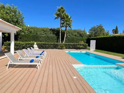 a deck with lounge chairs and a swimming pool at Stunning 4-Bedroom Villa With Pool - Perfect For Families in Albufeira