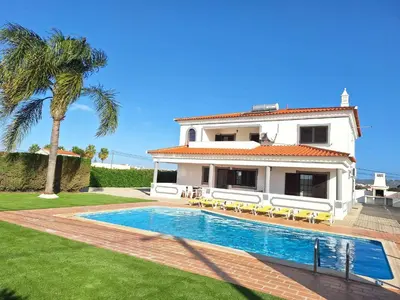 a tennis table on a patio with a pool at Villa Ramos by Ecovillas Albufeira in Roja- Pé