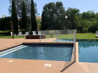 a swimming pool in a yard with chairs and trees at Vilamoura Club Villa 1 With Pool by Homing in Vilamoura