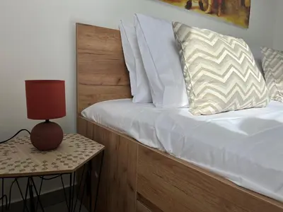 a bed with a wooden headboard next to a side table at Ocean view by Charmes Penthouse in Albufeira