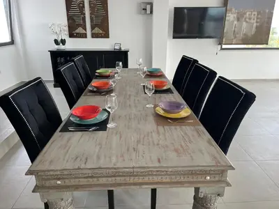 a wooden table with plates and wine glasses on it at Ocean view by Charmes Penthouse in Albufeira