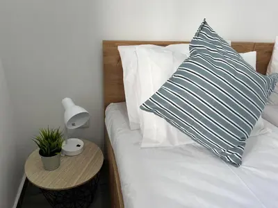 a bed with a pillow and a table with a lamp at Ocean view by Charmes B in Albufeira