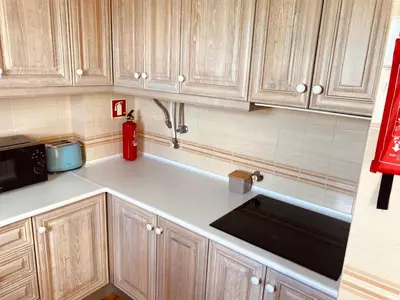 a kitchen with wooden cabinets and a black sink at T1 Vista Marina de Vilamoura in Vilamoura