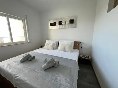 a bedroom with a large white bed with towels on it at Ocean view by Charmes C in Albufeira