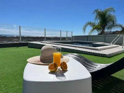 a table with a hat and a glass of orange juice at Ocean view by Charmes D in Albufeira