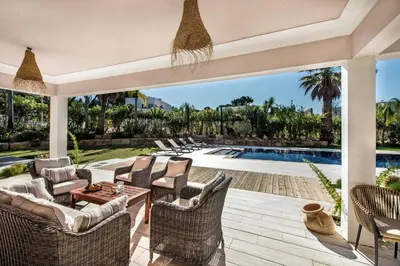 an outdoor patio with chairs and a swimming pool at Dazzling Almancil Villa Villa Magorian 4 Bedrooms Spacious Furnished in Almancil