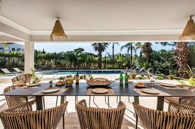 a dining room with a table and chairs and a pool at Dazzling Almancil Villa Villa Magorian 4 Bedrooms Spacious Furnished in Almancil