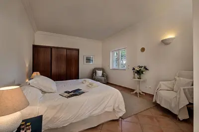 a bedroom with a large white bed and a chair at Dazzling Almancil Villa Villa Magorian 4 Bedrooms Spacious Furnished in Almancil
