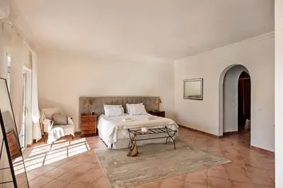 a white bedroom with a bed and a table at Dazzling Almancil Villa Villa Magorian 4 Bedrooms Spacious Furnished in Almancil