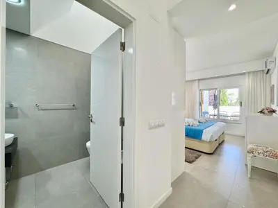 a bathroom with a shower and a bedroom with a bed at Vilamoura Club Villa 3 With Pool by Homing in Vilamoura