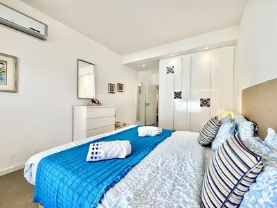 a bedroom with a large blue bed with pillows at Vilamoura Club Villa 3 With Pool by Homing in Vilamoura