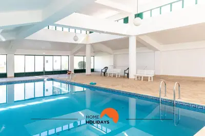 a large swimming pool in a large building with a dining area at #243 Jardins de Santa Eulália H23 by Home Holidays in Albufeira
