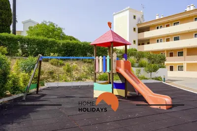 a playground in a parking lot with a slide at #243 Jardins de Santa Eulália H23 by Home Holidays in Albufeira