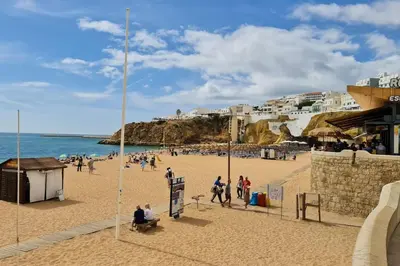 a group of people on a beach near the ocean at Apartamento T1 centro Albufeira in Albufeira