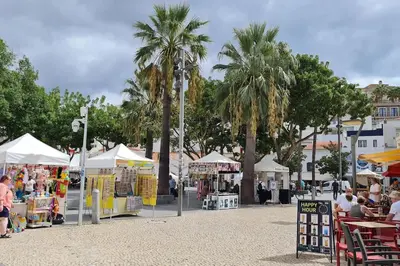 a market with palm trees and tables and tents at Apartamento T1 centro Albufeira in Albufeira