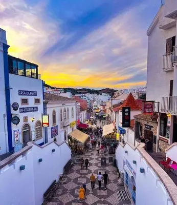 a group of people walking down a city street at Apartamento T1 centro Albufeira in Albufeira
