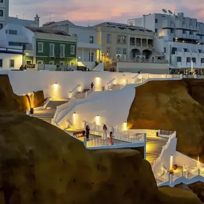 a group of people walking down stairs in a city at Apartamento T1 centro Albufeira in Albufeira