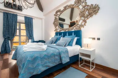 a blue bedroom with a large mirror and a bed at Oakmoon House in Faro