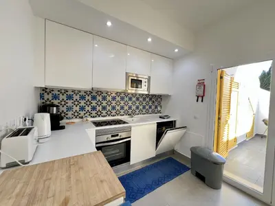 a kitchen with white cabinets and a stove top oven at Vilamoura Club Villa 2 With Pool by Homing in Vilamoura