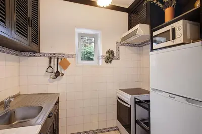 a small kitchen with a sink and a refrigerator at T1 em Vilamoura - Parque Mourabel in Vilamoura